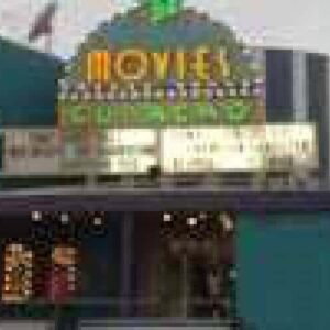 A festive teal theater decorated with lights features a brightly lit MOVIES marquee and multiple front windows. Poster displays are on the left, promoting the 2 for 1 movies special.
