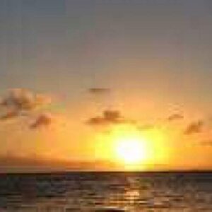 Bubbles on the boat" captures a yellow-orange sunset over calm ocean waters, where warm reflections dance as a small boat drifts near rising bubbles and golden-tinted clouds float in the softly illuminated sky.