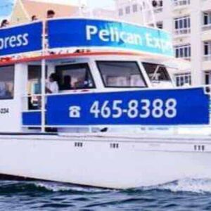 The white and blue Pelican Express catamaran offers the Harbour Trip, sailing near colorful waterfront buildings. Passengers ride on the upper deck under a clear sky. For details, call 465-8388.