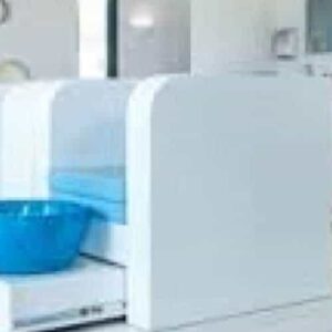 A bright, modern nail salon with white pedicure stations featuring cushioned blue seats and glossy blue foot basins. Circular wall décor and large windows create a clean vibe—ideal for your next Laman Manicure.