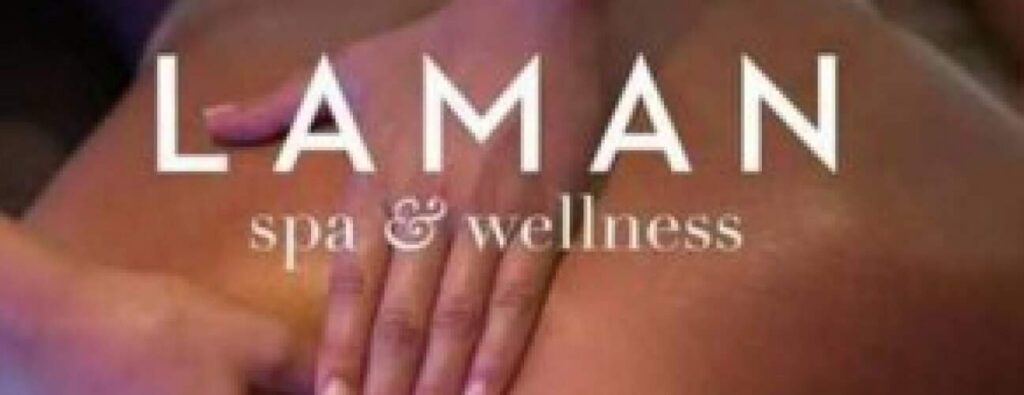 Een close-up toont de rug van een persoon die zachtjes wordt gemasseerd door twee handen. De woorden "Verwen me" verschijnen in witte hoofdletters en roepen een rustgevende en ontspannende spa-sfeer op.