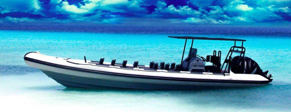 A Private boat - powerboat - speedboat charter in Curaçao is anchored in clear, shallow turquoise water, under a dramatic blue sky with swirling clouds—a bright, tropical setting.