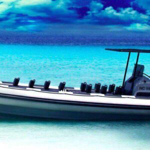 A Private boat - powerboat - speedboat charter in Curaçao is anchored in clear, shallow turquoise water, under a dramatic blue sky with swirling clouds—a bright, tropical setting.