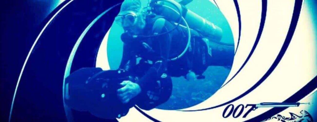 A scuba diver in full gear with a Private DPV dive setup holds an underwater camera, framed by the iconic swirling gun barrel graphic from James Bond films. The blue-tinted image features the 007 with gun symbol in the bottom right corner.