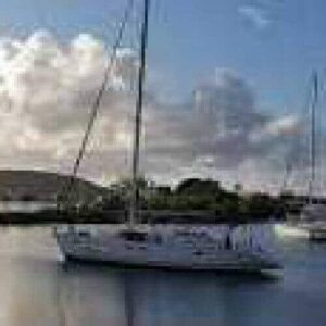 Experience tranquility on the VIP Sunset tour as elegant white sailboats glide across calm water beneath a bright sky with scattered clouds. Low green hills and distant mountains create a scenic harbor, while sunlight reflects off the serene surface.