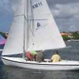 The Youth Sailing (Optimist) shows two people in life jackets on a small white sailboat gliding near a marina, with other boats and waterfront homes in the background—a perfect day for youth sailing.